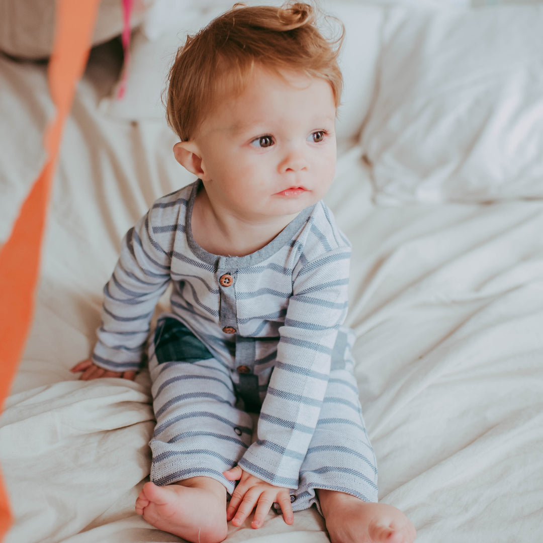 Baby boy wearing sustainable organic cotton baby playsuit