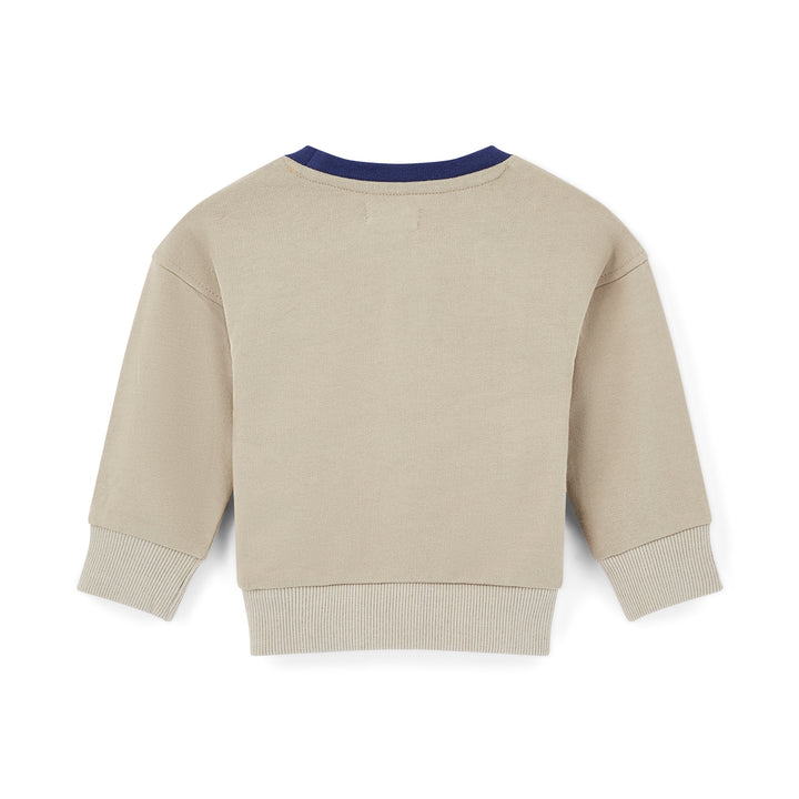 Beige sweatshirt with navy trim on a white background