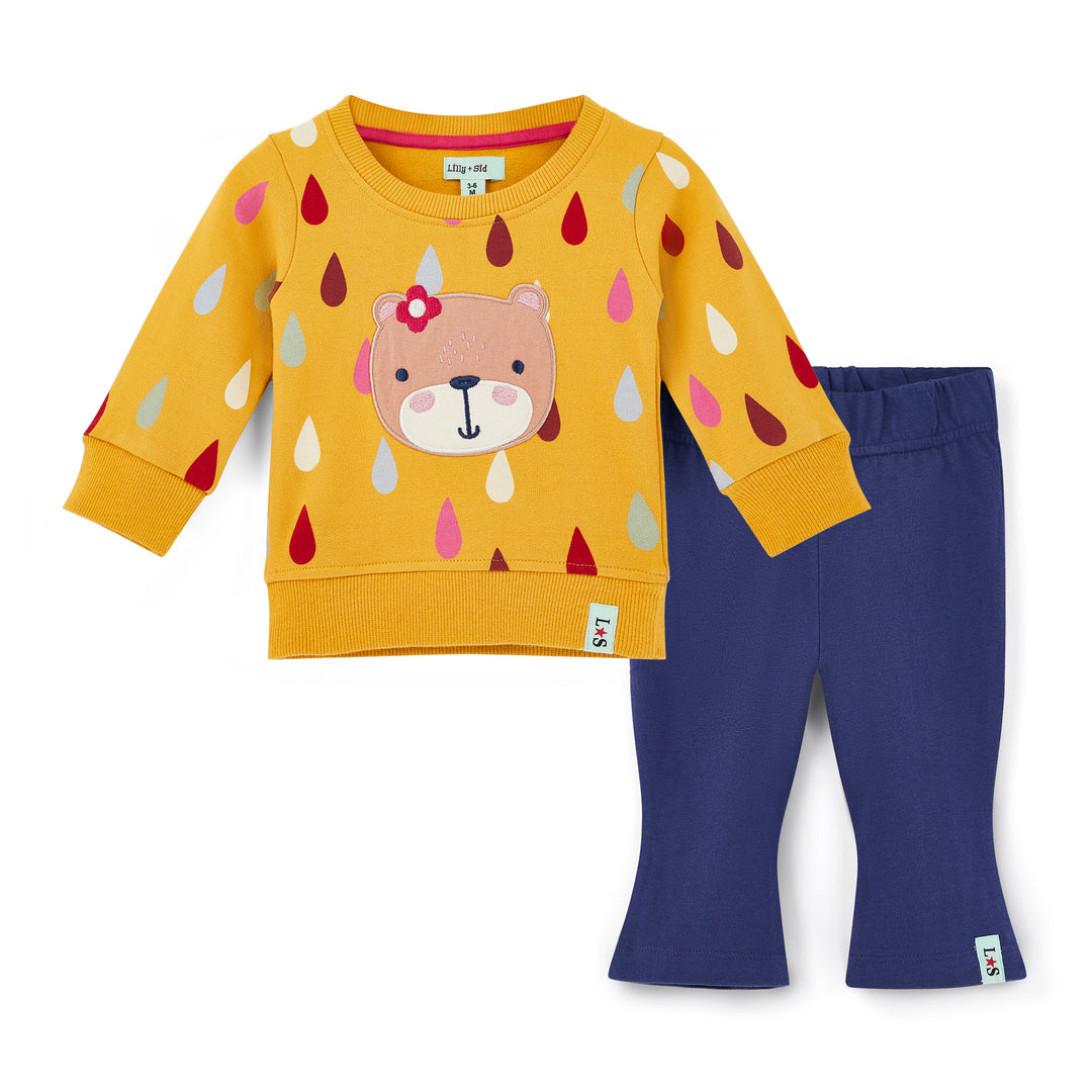 Children's outfit with yellow sweater and purple pants on a white background