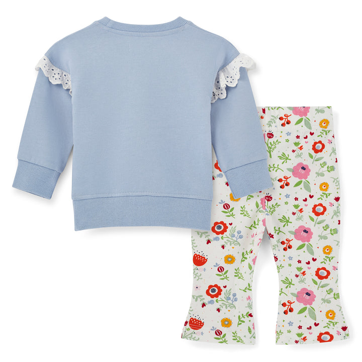 Children's outfit with blue sweater and floral pants on a white background