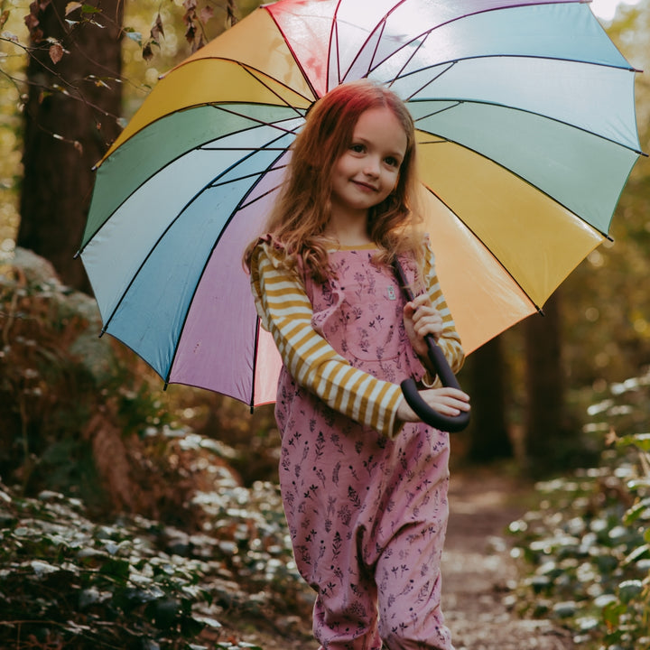 Girl in pink dungarees with an umbrella