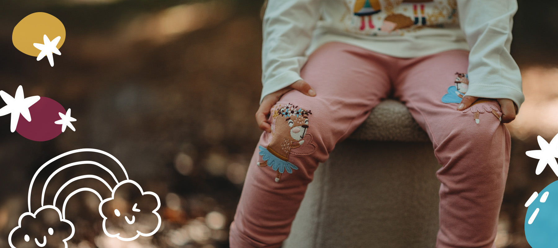 Girl sitting down wearing our fairy Lilly and Sid knee patch leggings in pink. 