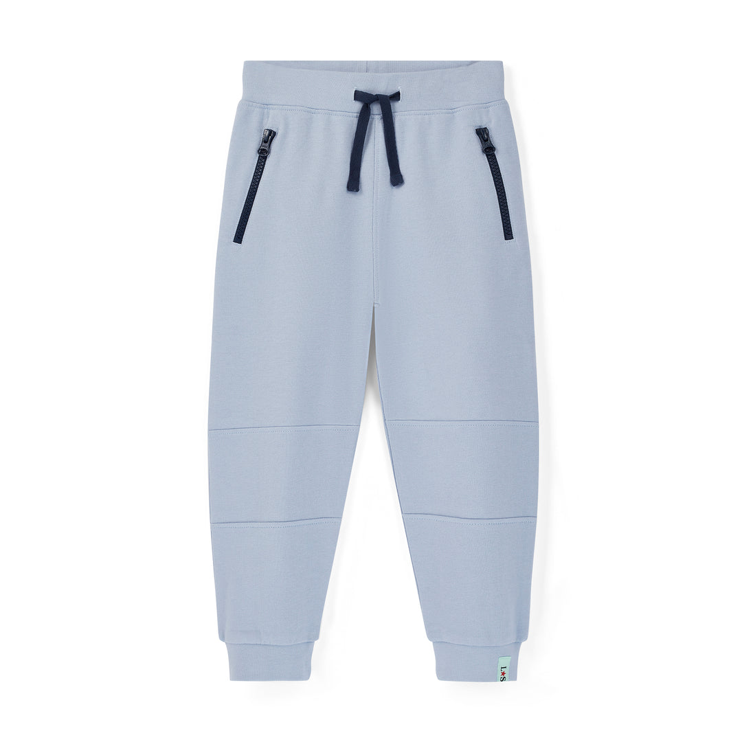 Light blue jogger pants with black zippers on a white background