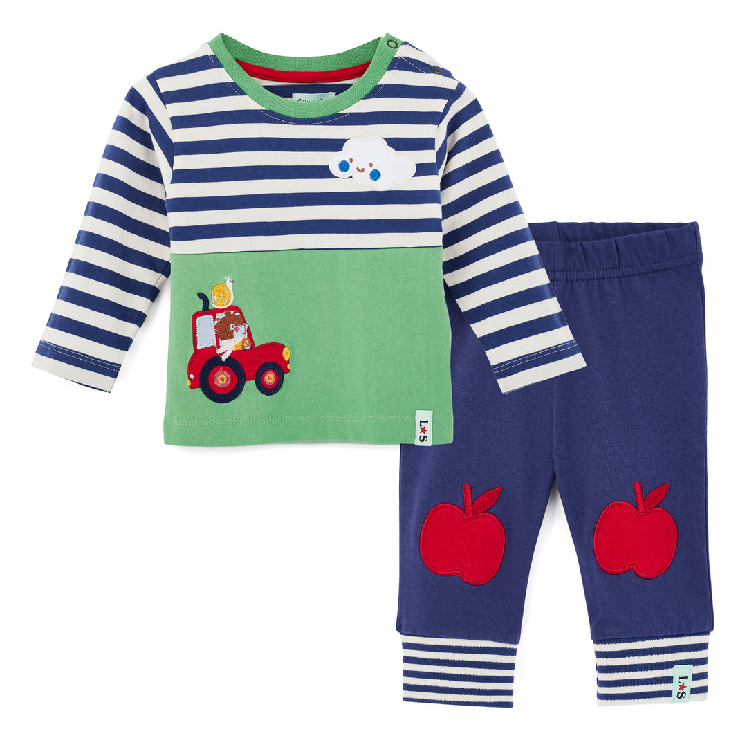 Children's outfit with striped shirt and green patch featuring a red fire truck, and blue pants with red apple designs on a white background.