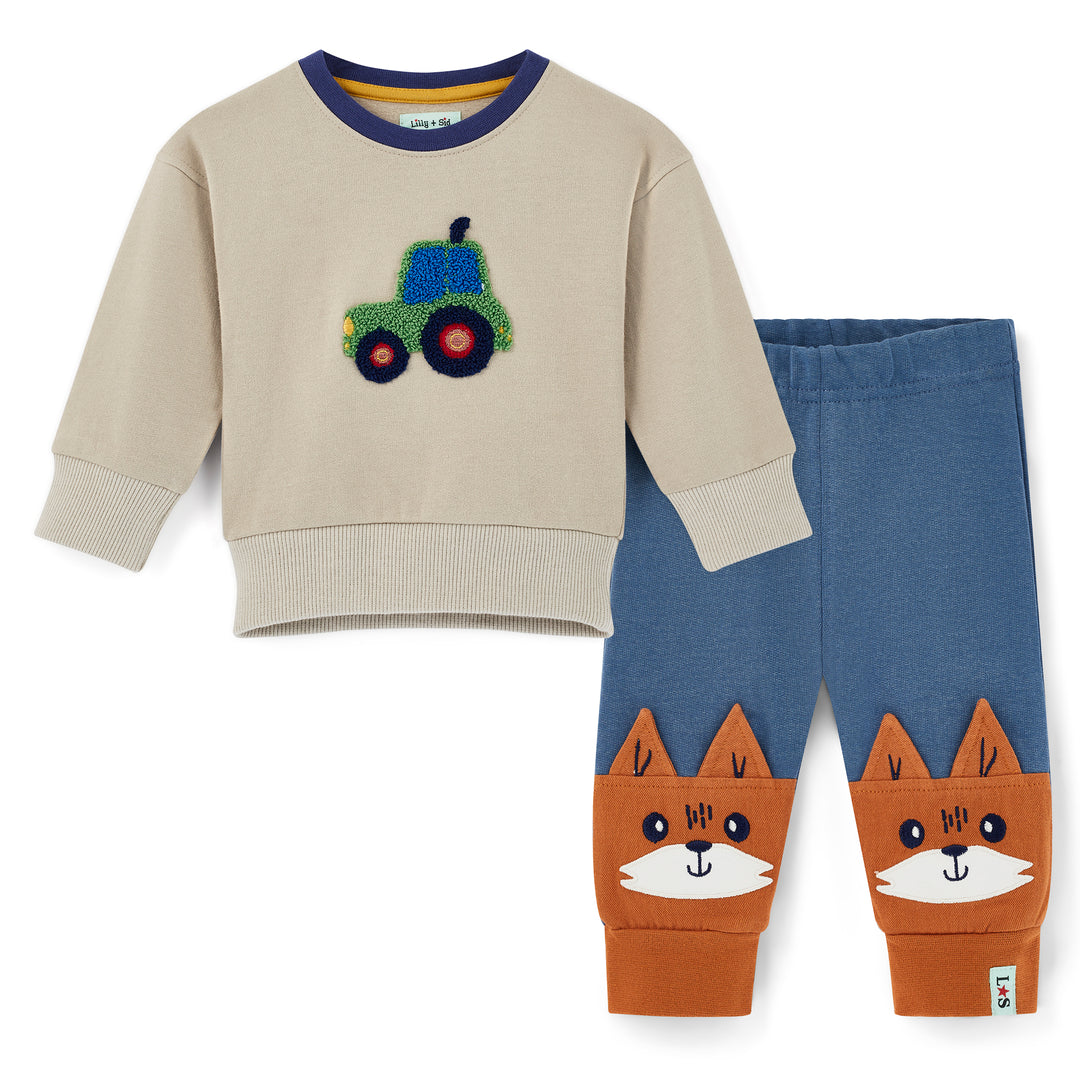 Children's outfit with beige sweater and blue pants featuring a fox design on a white background