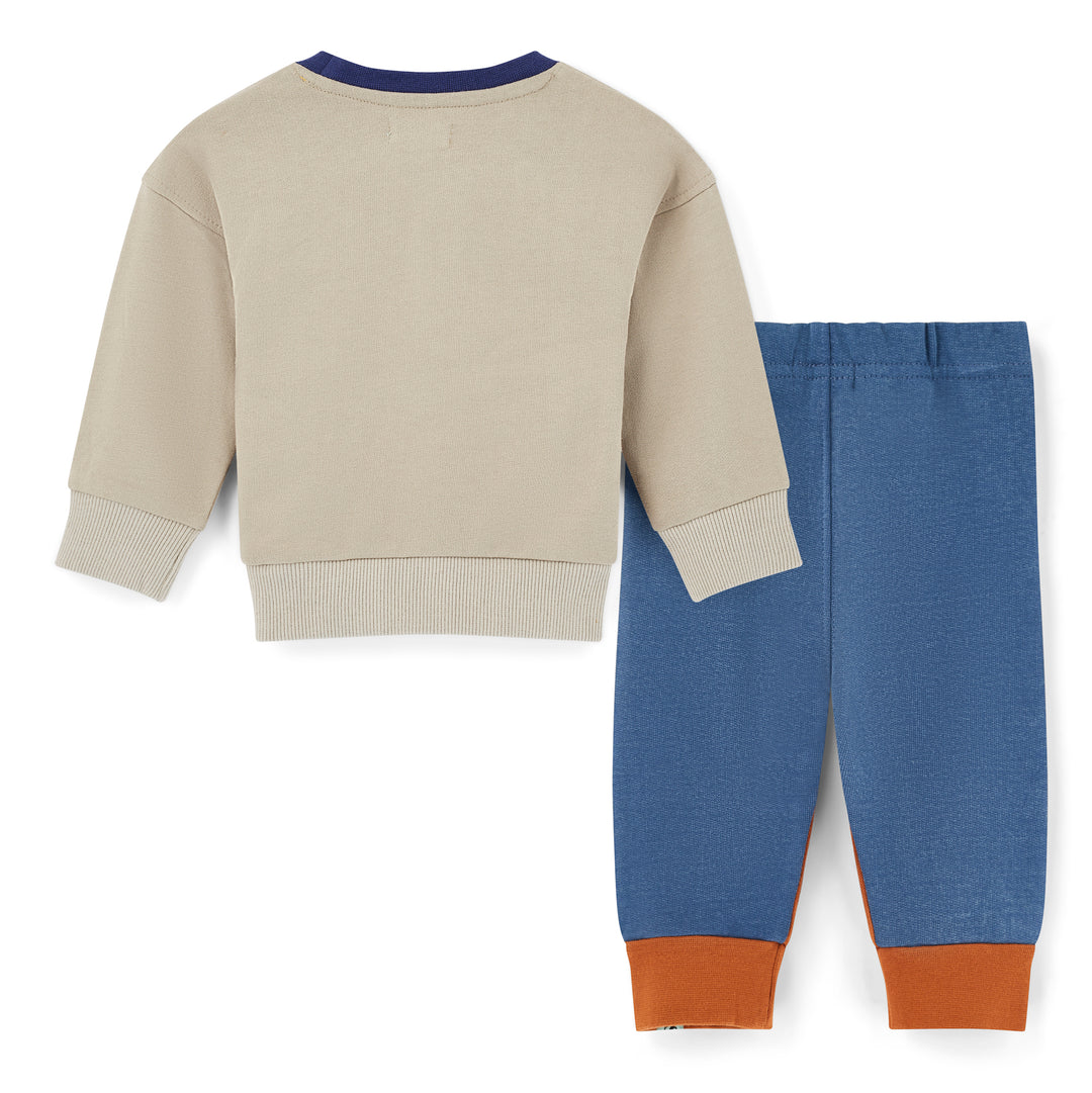 Children's beige sweater and blue pants with brown cuffs on a white background