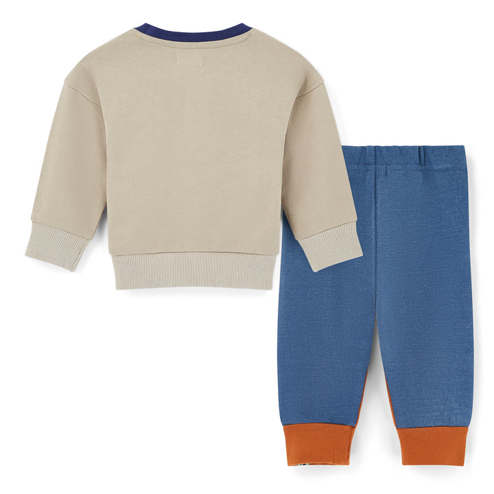 Children's beige sweater and blue pants with brown cuffs on a white background