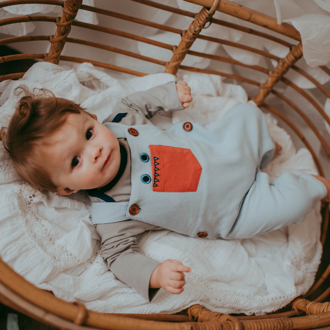 Baby boy wearing sustainable organic cotton baby rib dungarees.