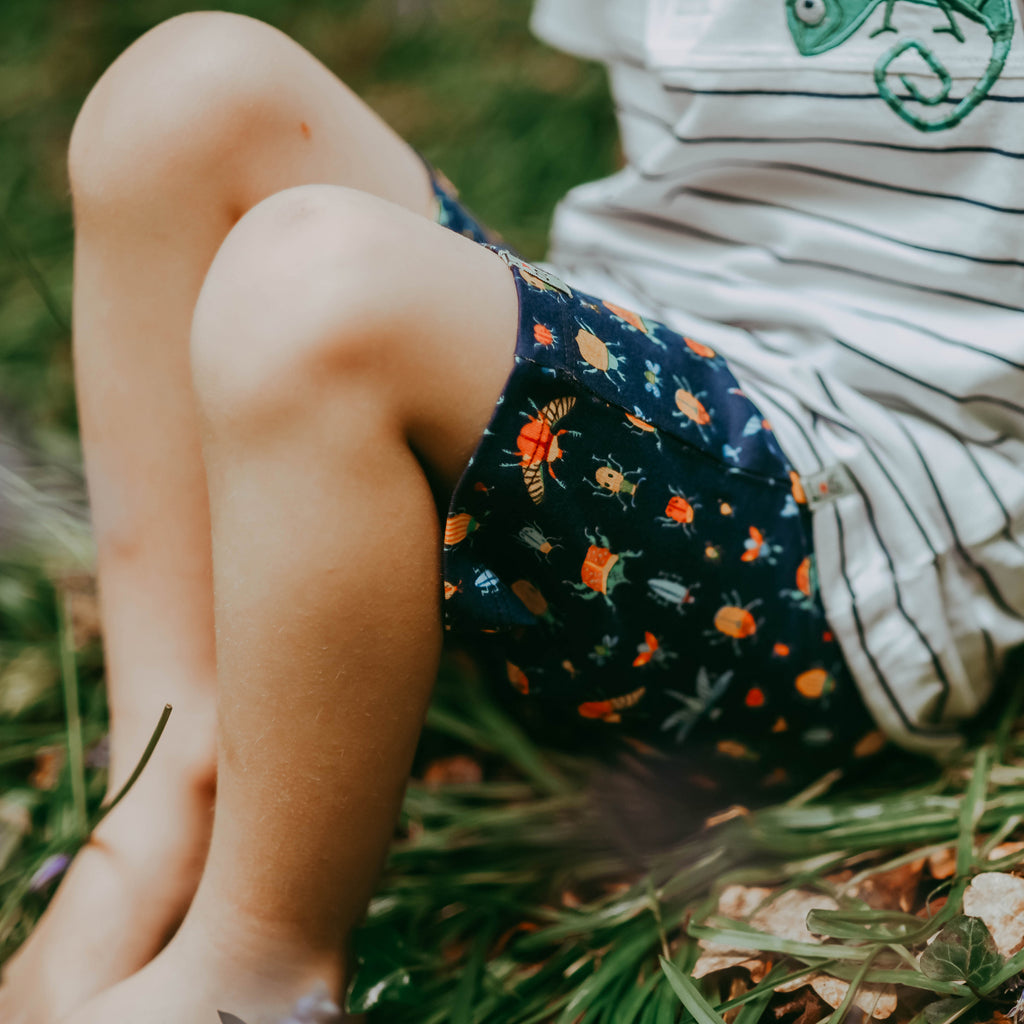 a boy sitting wearing bug shorts made from organic cotton