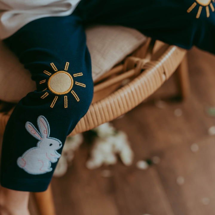 Girl wearing navy blue bunny and sun leggings